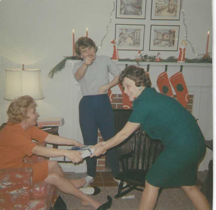 Mary Lou, as referee between sister Lois and another sister, fighting over a Christmas gift.  1961?  (Susie's first tmas)
