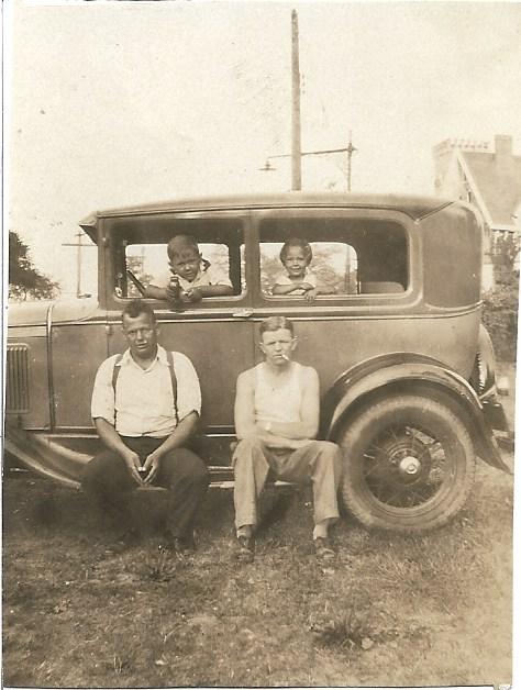This is a photo of the family's first car.  Sylvia and her brother Ralph are sitting inside the car.
