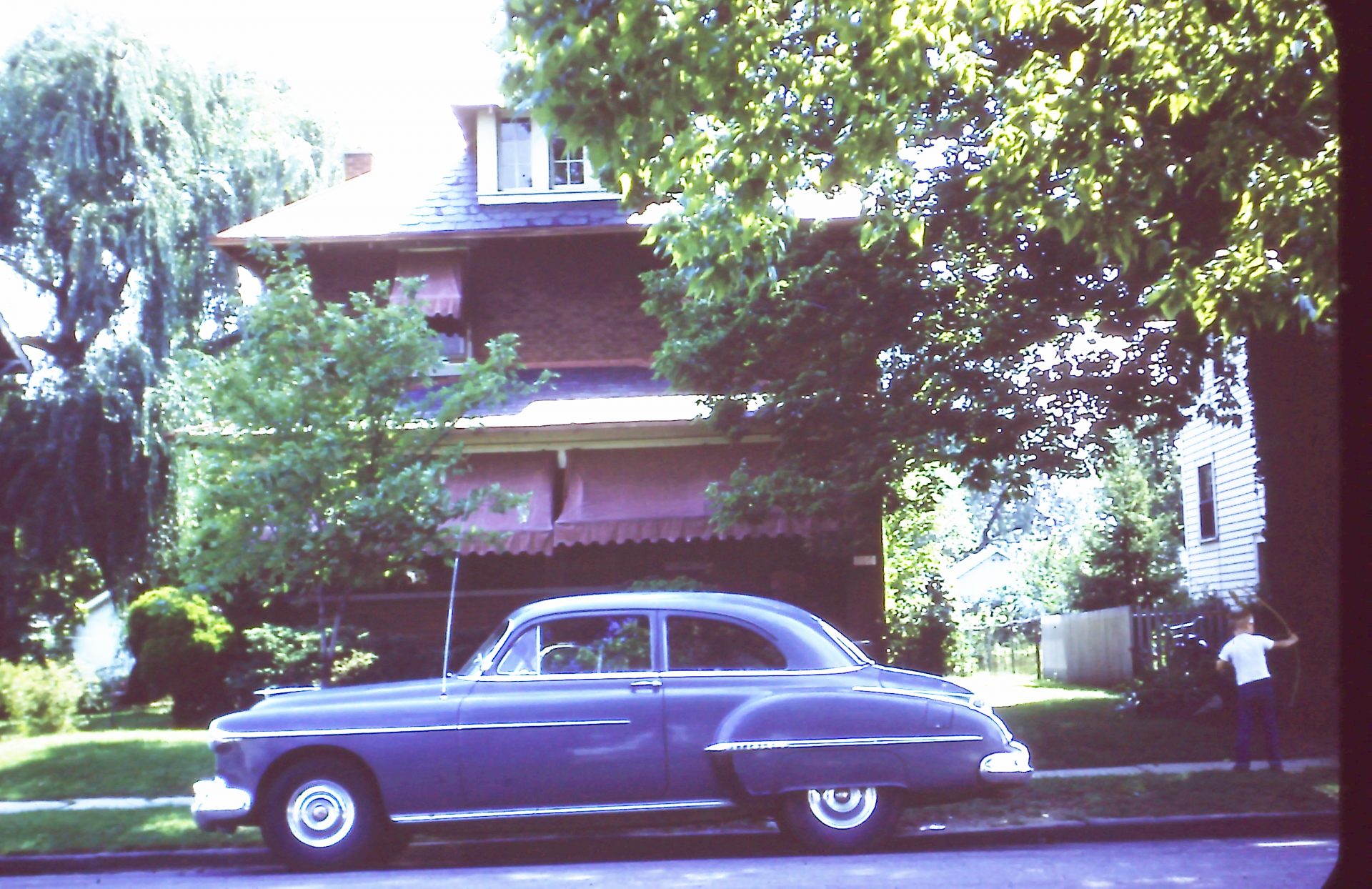 One of Dad's first cars.  Notice the kid playing with the Bow and Arrow, and the Burgess house!