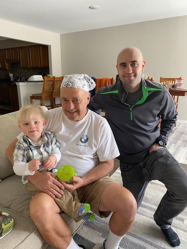 Jim is beaming with his son and grandson.