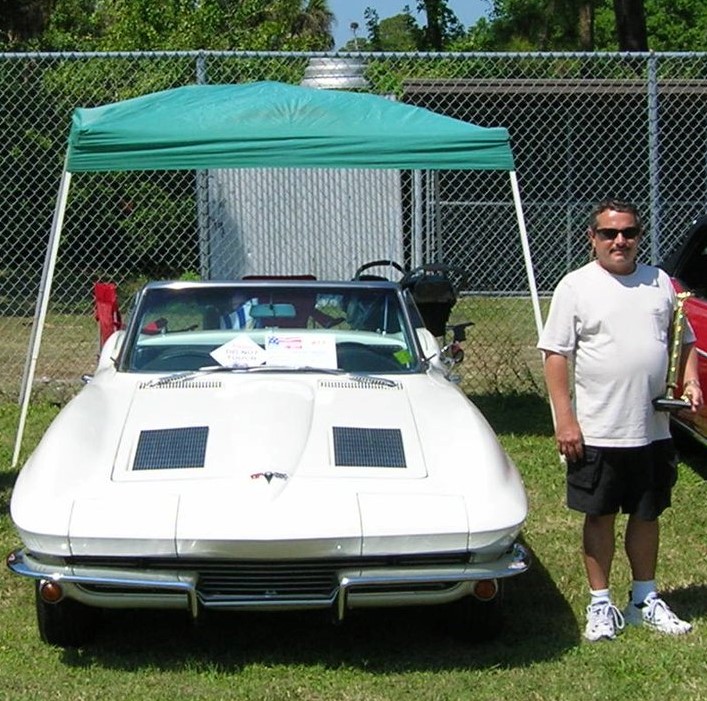 Roger an his prized Corvette and a trophy he won with it.