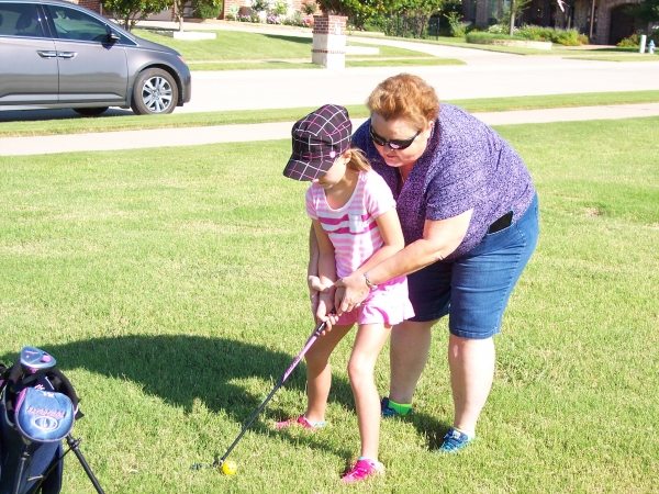 Teaching the finer points of golf to her granddaughter